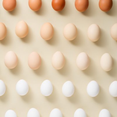 Egg pattern, gradient from different color chicken eggs on beige background, top view, flat lay, minimal easter concept